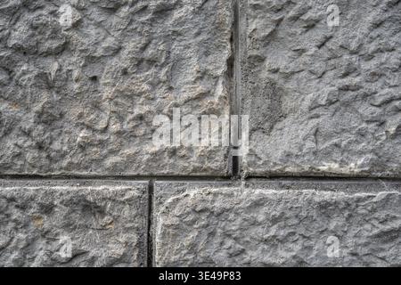 Rough gray stone wall background showing textured masonry block surface Stock Photo