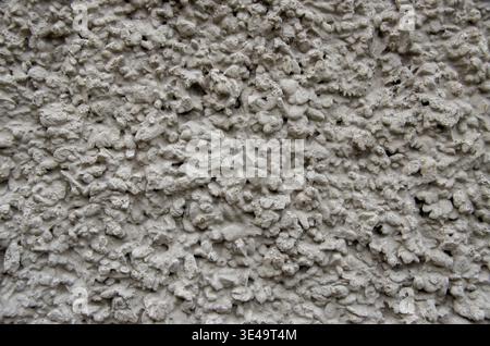 Rough gray stucco wall texture creating an abstract surface background Stock Photo