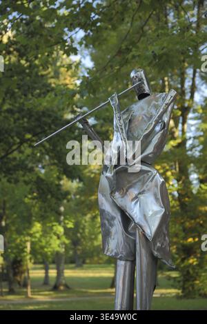 Flute player sculpture, modern art, sitting metal sculpture with flute, brass, playing, making music, State Music Academy, Schlitz, Vogelsberg, Hesse Stock Photo
