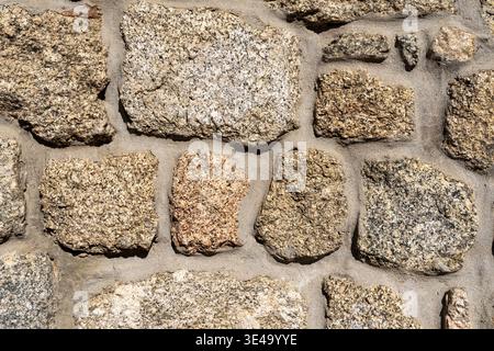 Wall made of granite natural stones as background or texture Stock Photo