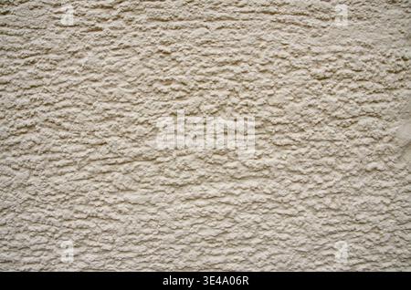 Beige stucco wall displaying rough plaster texture creating a solid background Stock Photo