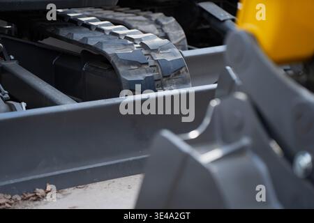Industrial compact excavator parked on a worksite showing heavy duty tread and mechanical assembly for building development residential construction a Stock Photo