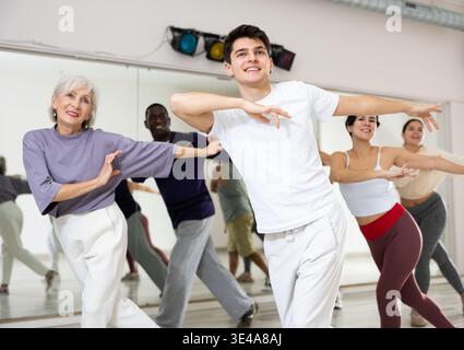 Cheerful guy practicing modern vigorous dance with group Stock Photo
