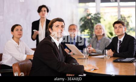 Group of business people attending meeting in conference room, discussing work plan Stock Photo