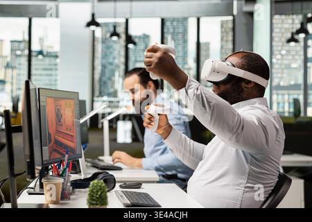 Black game developer designing assets with VR headset at the office, working on spatial video game in space. Engineer uses modeling tools on animation software, creating futuristic virtual world. Stock Photo