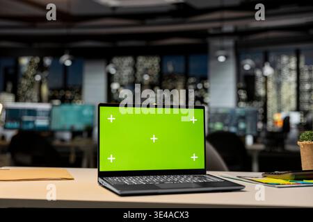 Chroma key screen on laptop in empty boardroom for modern organization, forecasts on digital displays. Corporate space represents business planning and management vision, growth strategy. Stock Photo