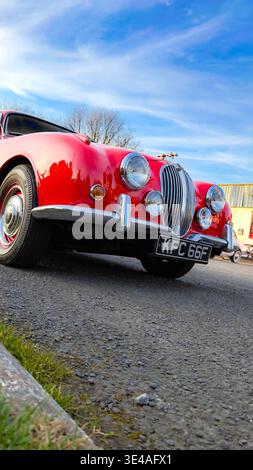 Low angle front view of a classic red Jaguar Mark 2 car parked outdoors under a blue sky Stock Photo