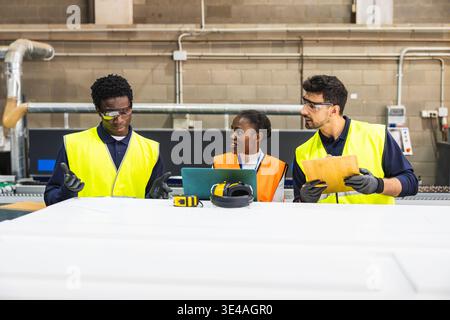 Diverse industrial workers having team meeting in lumberyard Stock Photo
