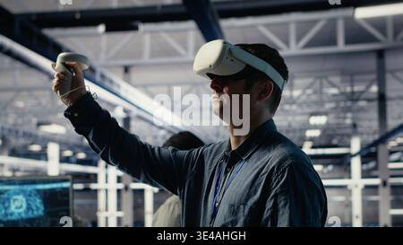 Server farm programmer uses VR headset to install updates and keep AI systems running. Data center employee uses virtual reality tech to write code improving infrastructure output, camera B Stock Photo