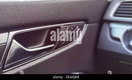 Car Door Interior Handle Lock and Mirror Control Close Up Stock Photo