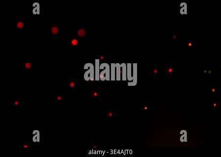 Simple and minimal composition of red glowing bokeh dots scattered on a deep black background. Ideal for abstract, night, or elegant design concepts. Stock Photo