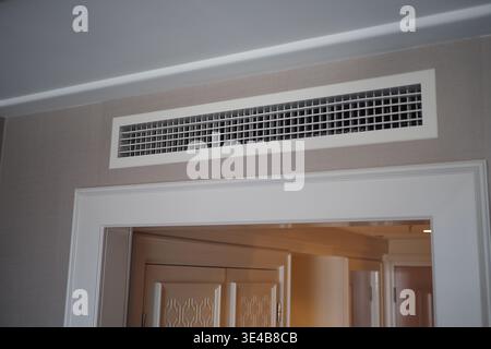 Air vent located above a doorway in a room setting Stock Photo