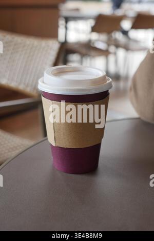 Coffee cup sits on table in cafe during the morning Stock Photo