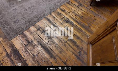Old wooden floor with rug in a room Stock Photo
