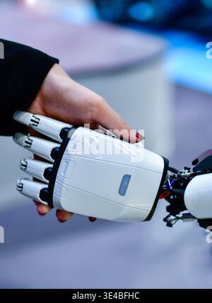 Advanced bionic robotic hand shaking hands with human, symbolizing AI and human collaboration. Stock Photo