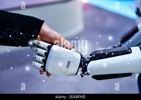Advanced bionic robotic hand shaking hands with human, symbolizing AI and human collaboration. Stock Photo