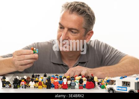 Middle aged man playing with lego Stock Photo