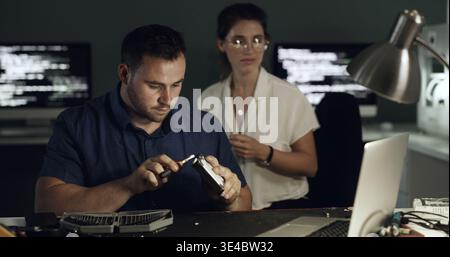 Hard drive, repairs and technician with manager in office for maintenance, upgrade or fixing server. Laptop, equipment and male engineer building Stock Photo
