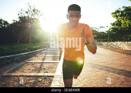 Athlete, black man and running for fitness at park with exercise, speed training and cardio. Serious, male person and runner sprint for physical Stock Photo