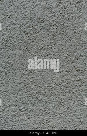 Close up of a gray plaster wall with rough uneven texture and fine grain detail. Stock Photo