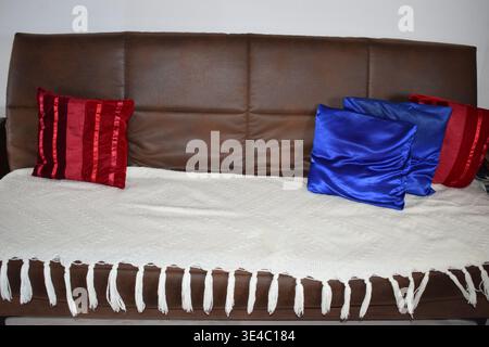 brown sofa with white cover, red and blue decor Stock Photo