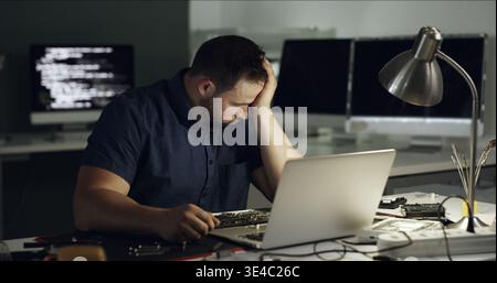 Stress, man and programming with laptop at office for coding error, data loss and software crash. Frustrated, male person and troubleshooting pc with Stock Photo