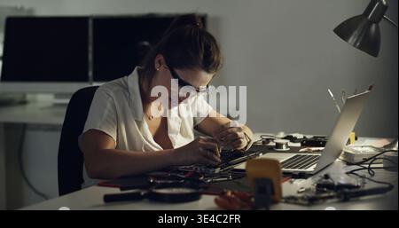 Woman, technician and repair with laptop in workshop for IT service, maintenance or engineering. Female person, specialist or inspection with Stock Photo