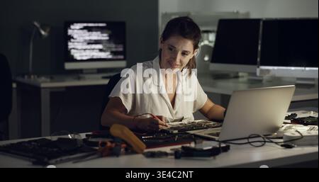Night, laptop and woman with hardware for IT maintenance, repair and diagnostics for software. Technology, technician and female engineer with tools Stock Photo