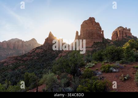 Sun setting behind red rock formations Stock Photo