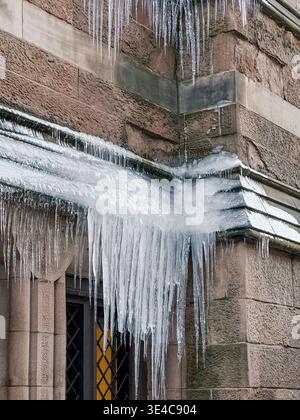 Large icicles hanging from stone building in Brooklyn Stock Photo
