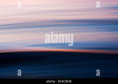Abstract ocean motion with sunset light streak across wave Stock Photo