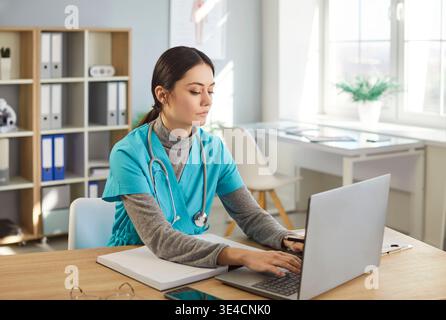 Focused Female Doctor Researching Online In Clinic Stock Photo
