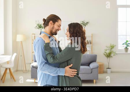 Loving young couple hugging, looking into each other eyes and enjoying romantic moment together. Stock Photo