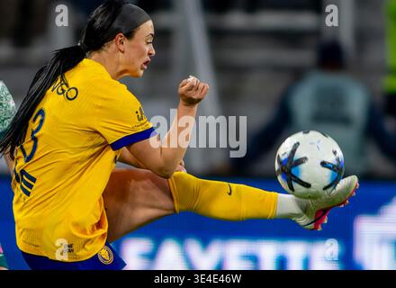 A female soccer player boots the ball Stock Photo