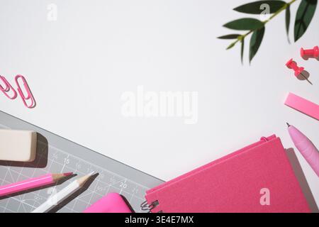 Creative workspace with cutting mat, pink notebook, pencils, pen and stationery on white desk. Copyspace. Stock Photo