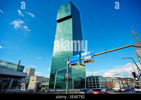 Zurich, Switzerland, March 26, 2026. Wide, low angle view of the green glass prime tower against a blue sky with overhead road signs for Winterthur an Stock Photo