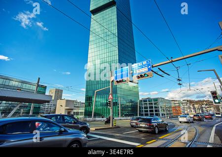 Zurich, Switzerland, March 26, 2026. Wide, low angle view of the green glass prime tower against a blue sky with overhead road signs for Winterthur an Stock Photo