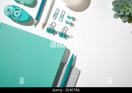 Flat lay of green office stationery and school supplies on a grey cutting mat. Copyspace Stock Photo