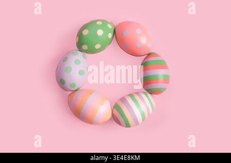 decorative painted Easter eggs lie in a ring on a pink background Stock Photo
