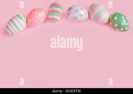 Easter multi-colored eggs on a pink background lie in a row Stock Photo