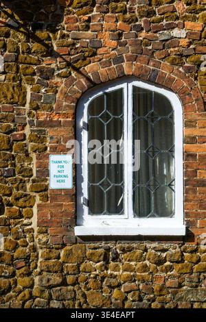 A Thank You for Not Parking Here sign on an old building. Stock Photo