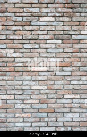 Vintage loft style brick wall texture with a mix of red, white, and grey bricks.  Rustic reclaimed brickwork background, weathered masonry surface for Stock Photo