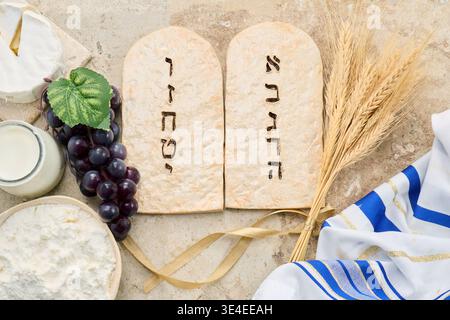 Shavuot holiday symbols with ten commandments tablets and dairy. Stock Photo