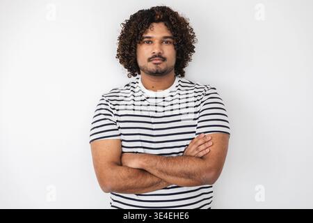 Young Indian man standing with arms crossed portrait Stock Photo