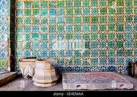 Visitors observe the detailed mosaic tiles and stone elements in Topkapi Palace in Istanbul during a sunny day. Stock Photo