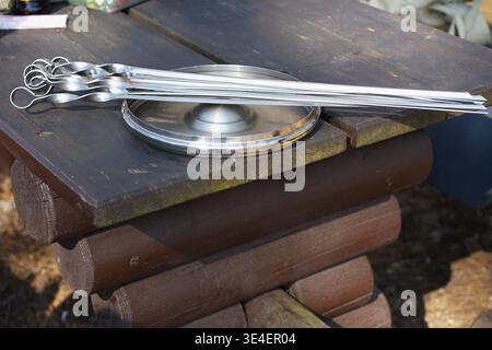 A set of skewers for cooking shashlik on a wooden table in the forest. High quality photo Stock Photo