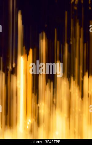 Abstract intentional camera movement image of golden sunrise light streaking through tree foliage in Somerset, creating an atmospheric background Stock Photo