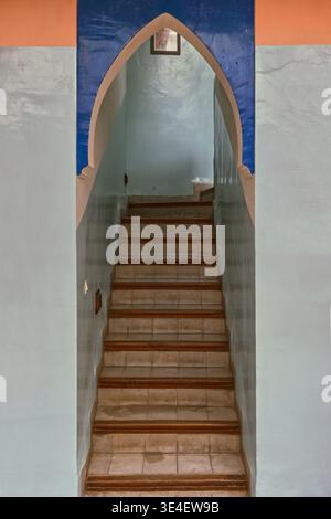 258 Horseshoe-arched doorway at the beginning of the stairway to the upper floors, entrance to a traditional house in the medina. Marrakesh-Morocco. Stock Photo