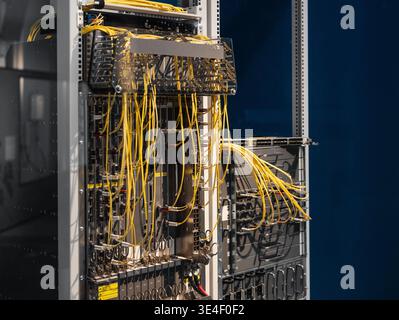 Two server racks with bright yellow cables. Data center's core network switch with numerous computers and routers - data center modular architecture. Stock Photo