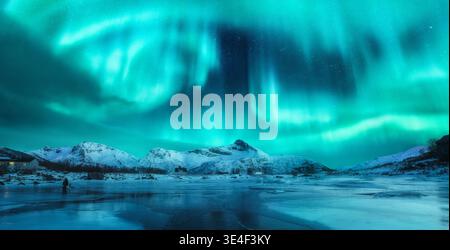 Northern lights over snowy mountains, frozen sea coast Stock Photo